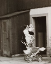 Frau steht mit Kinderwagen