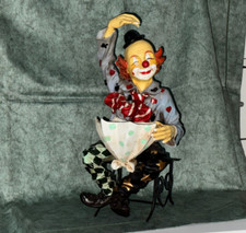 Deko-Figur: Fröhlicher Clown sitzt auf Metallbänkchen, 35 cm
