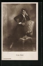 AK Schauspielerin Eva May posiert am Stuhl im langen schwarzen Kleid 