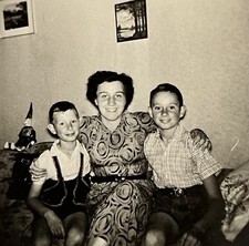 Frau Mutter sitzt stolz lachend mit zwei Jungen Söhnen Wohnzimmer Kasperle Foto