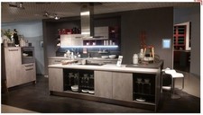 Einbauküche mit großer Insel in Betongrau mit Einbaugeräten Musterküche