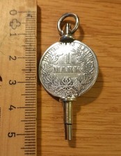 Uhrenschlüssel mit Münze von