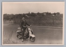Mann sitzt auf Motorroller mit
