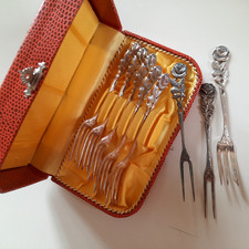 6 silbrige Kuchengabeln und 2 Aufschnittgabeln(?) in Aufbewahrungsdose