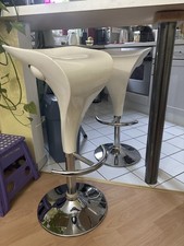 Zwei weiße höhenverstellbare Barhocker aus strapazierbarem Kunststoff.