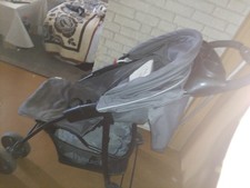 kinderwagen marke aprica ist in grau weiß und hat Winni Pooh drauf