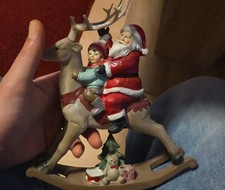 Weihnachtsmann mit Kind auf Schaukelhirsch/ Schaukelpferd rot