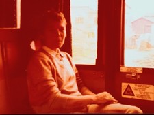 Frau sitzt scheu lächelnd im