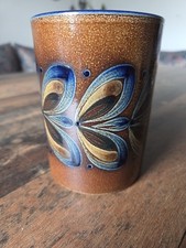 Keramikbecher mit einer braunen, gesprenkelten Glasur und einem blauen Rand.