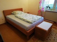 Gaestebett mit Truhe und Tischchen