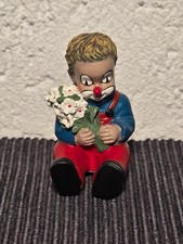 Gilde Clown sitzend mit Blumen