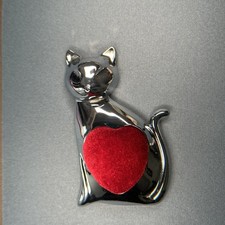 Sitzende Katze mit Nadelkissen