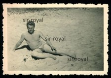 Mann in Badehose am Strand mit