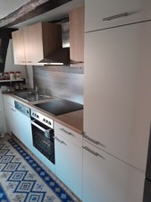 Küchenschränke, Geschirrspüler und Kühlschrank. Der Ofen ist ausgeschaltet.