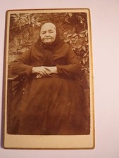 Alte Frau mit Kopftuch sitzt