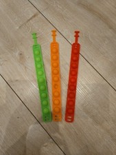 drei Armbänder für Kinder, Pop-Its, grün, orange, rot
