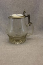 Bierkrug aus Glas mit Zinndeckel.