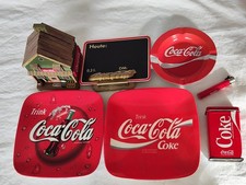 Auflösung: 3 Coca Cola Aschenbecher, Blechdose, Feuerzeug, Tafel und Häuschen