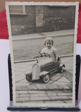 Altes s/w Foto Mädchen im Tretauto auf der Straße