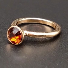 Schlichter goldfarbener Ring mit dunkelorangenem Stein