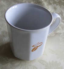 Kaffeebecher Tchibo, weiß mit der goldenen Kaffeebohne als Motiv