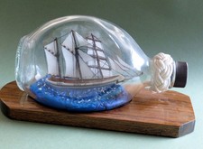 Atraktives Buddelschiff auf einer Holzplatte