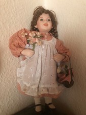 Puppe mit braunen Zöpfen, mit Körbchen, aus Hartplastik oder ähnlichem Material