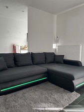 Dreisitzer-Sofa in Schwarz mit LED-Beleuchtung.