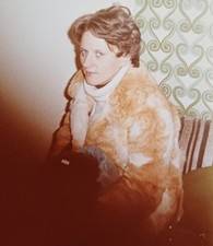 Frau im Pelzmantel sitzt auf