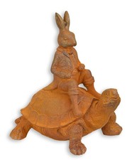 Eine rostige Gusseisenfigur eines Hasen, der auf einer Schildkröte reitet Replik