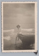 Frau am Meer sitzt auf Boot -