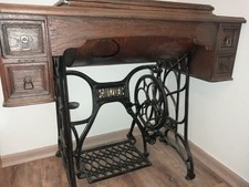 Alte Glitzner Nähmaschine mit goldenen Applikationen und Tisch