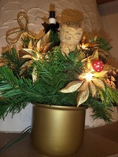 Gesteck Weihnachtssterne beleuchtet im goldenen Topf mit Neujahrsfeatures