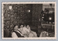 Mann mit Puppe und Frauen vor Wandtapete der 50er - Altes Foto