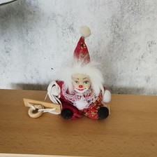 Harlekin, Clown auf Schaukel sitzend