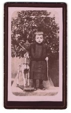 Fotografie Portrait kleines Mädchen im Kleidchen mit Schaukelpferd auf Rollen 