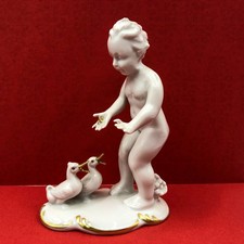 Porzellan Putte füttert