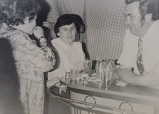 Mann sitzt lachend mit zwei