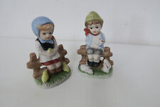 2 Figuren Mädchen mit Kücken  -  Junge mit  Hasen  sitzend auf den Gartenzaun