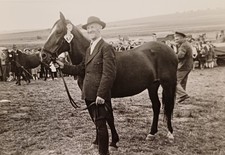 Mann steht stolz mit Rennpferd