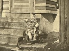Eisfeld süße Mädchen sitzt im Schaukelpferd vorm Haus Treppe Kleinkind Baby Foto
