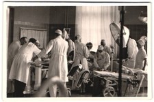 Fotografie Ärzte während einer OP im OP-Saal, blutige Kittel, Instrumente 