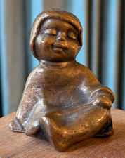 Kleine Bronze-Figur eines sitzenden Kindes