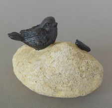 Vogel mit Wurm auf Stein