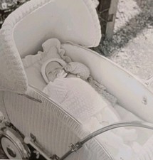 Süßes Baby in Strampler Strickjacke Mütze liegt in Korb Kinderwagen Altes Foto