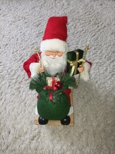 Weihnachtsmann auf Schlitten mit Sack und Geschenkbox