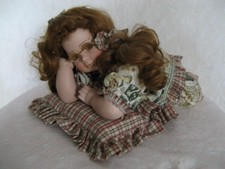 Liegendes Puppenkind aus Porzellan mit Kissen