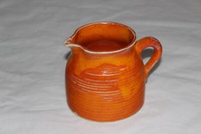 Krug oranger kleiner Milchkrug