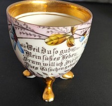 Antike rosa Porzellantasse mit Spruch auf drei goldenen Füßen