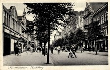 Ak Neumünster in Holstein, Kuhberg, Straßenpartie mit Geschäften - 11200820